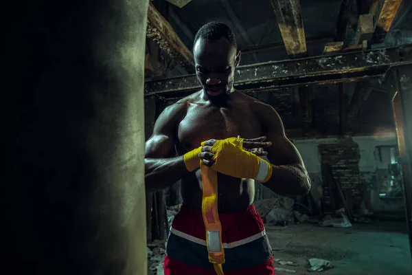 Boxeador afro-americano está enrolando as mãos com bandagem — Fotografia de Stock