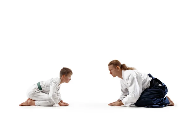 Мальчик и мальчик-подросток на тренировке айкидо в школе боевых искусств — стоковое фото