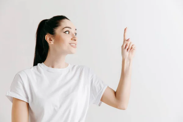 La mujer feliz de pie y sonriendo contra el fondo gris . —  Fotos de Stock