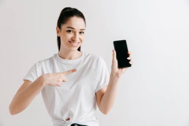 Kendine güvenen casual kız gösteren boş bir ekran cep telefonu portresi