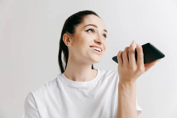 Portrait intérieur d'une jeune femme séduisante tenant un smartphone vide — Photo