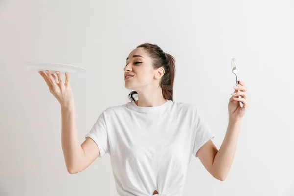 Young menyenangkan gila brunette ibu rumah tangga dengan garpu terisolasi di latar belakang putih — Stok Foto