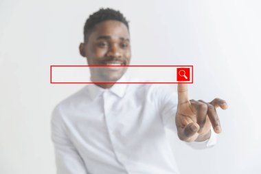 Genç Afrikalı Amerikalı adam boş arama çubuğu ile etkileşime girer. Metninizi eklemek için negatif alan.