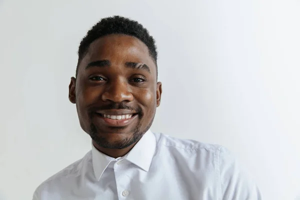 Close up portrait of a happy young african american man laughing against gray background. — Stock Photo, Image