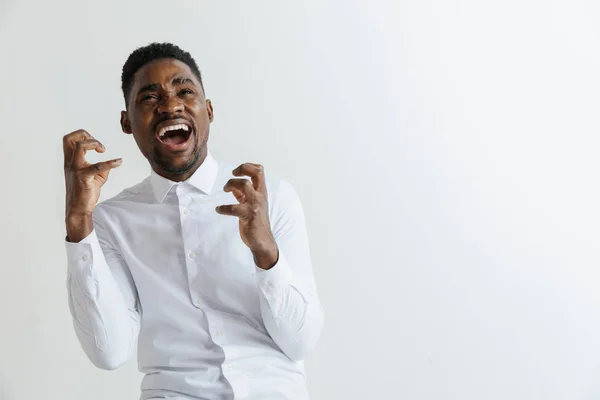 Ena! Retrato dianteiro masculino atrativo de meia-extensão em backgroud de estúdio cinza. Jovem afro emocional surpreendido barbudo homem de pé com a boca aberta. Emoções humanas, conceito de expressão facial . — Fotografia de Stock