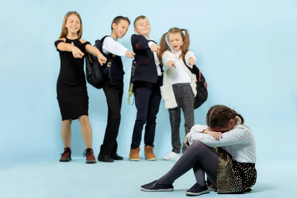 Kleines Mädchen sitzt allein auf dem Boden und leidet unter Mobbing. — Stockfoto