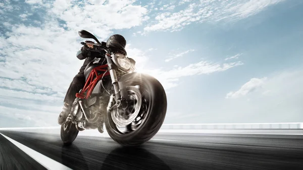Motociclista in autostrada, in giro per una curva con una sfocatura movimento tonica — Foto Stock