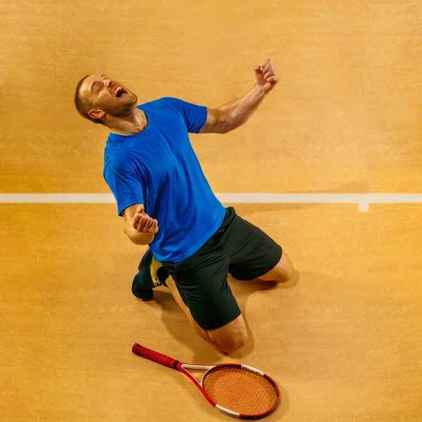 Retrato de um belo tenista do sexo masculino comemorando seu sucesso na corte — Fotografia de Stock