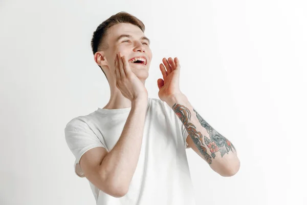 El hombre de negocios feliz de pie y sonriendo contra el fondo gris . — Foto de Stock