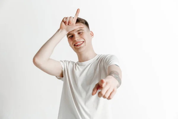 Losers go home. Portrait of happy guy showing loser sign over forehead — Stock Photo, Image