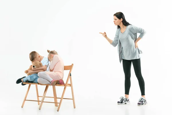 Angry mother scolding her son in living room at home