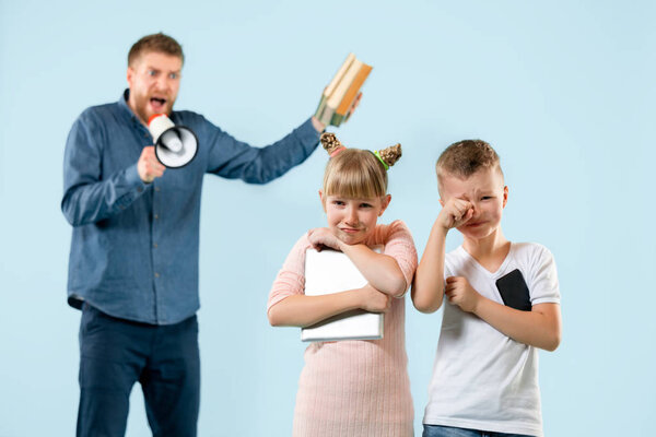 Angry father scolding his son in living room at home