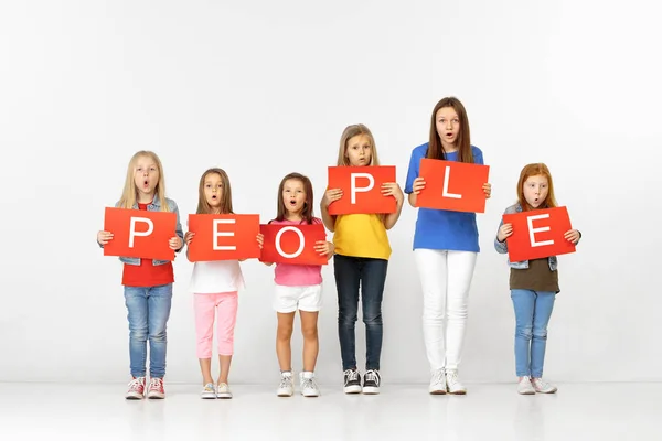 Mensen. Groep kinderen met rode banieren geïsoleerd in wit — Stockfoto