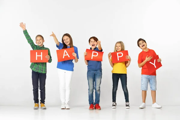 Szczęśliwy. Grupa dzieci z czerwonymi banerami wyizolowanymi w bieli — Zdjęcie stockowe