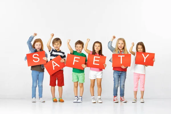 Safety. Group of children with red banners isolated in white — Stock Photo, Image