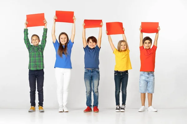 Gruppo di bambini con striscioni rossi isolati in bianco — Foto Stock