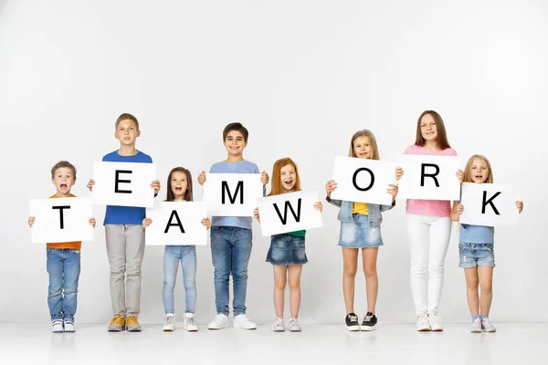 Teamwork. Groep van kinderen met een banner geïsoleerd in het wit — Stockfoto