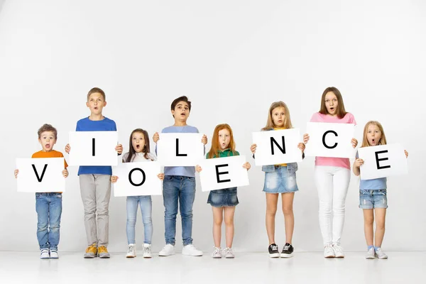 Våld. Grupp av barn med en banderoll isolerad i vitt — Stockfoto