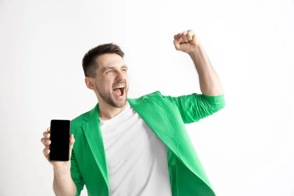 Mladý pohledný muž zobrazení smartphone obrazovky a podepisování Ok izolované na šedém pozadí — Stock fotografie