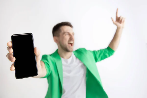 Молодий красивий чоловік показує екран смартфона і підписує OK ізольовано на сірому фоні — стокове фото