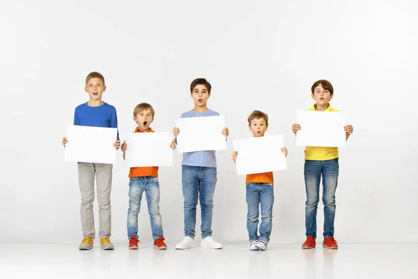Gruppe von Kindern mit einem weißen Banner isoliert in weiß — Stockfoto