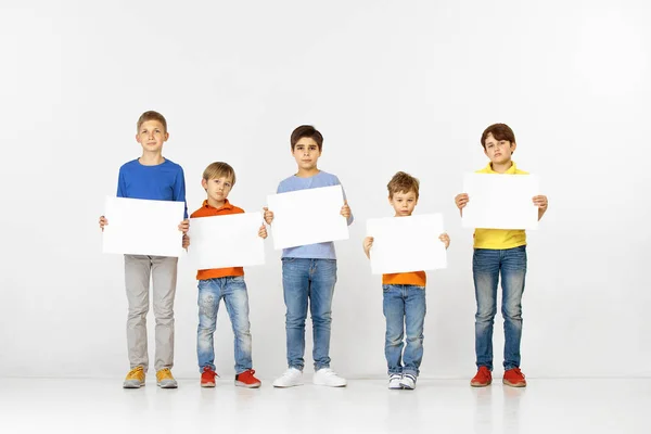 Gruppe von Kindern mit einem weißen Banner isoliert in weiß — Stockfoto