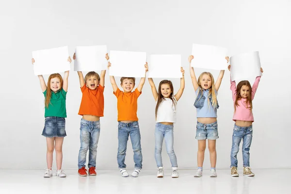 Gruppe von Kindern mit einem weißen Banner isoliert in weiß — Stockfoto