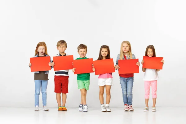 Gruppo di bambini con striscioni rossi isolati in bianco — Foto Stock