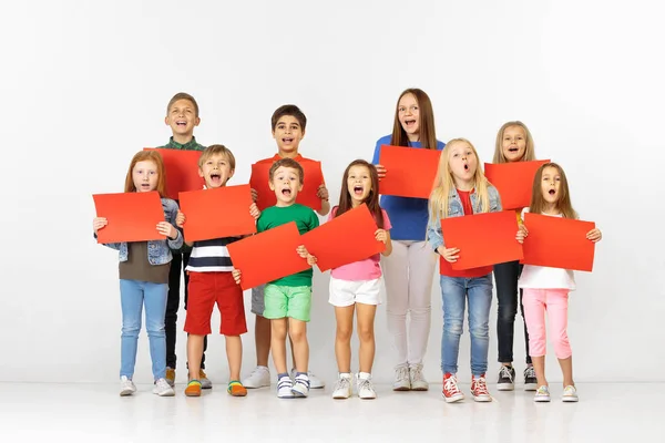 Groep kinderen met een rode banners geïsoleerd in wit — Stockfoto