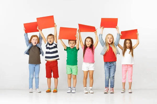 Grupo de niños con pancartas rojas aisladas en blanco — Foto de Stock