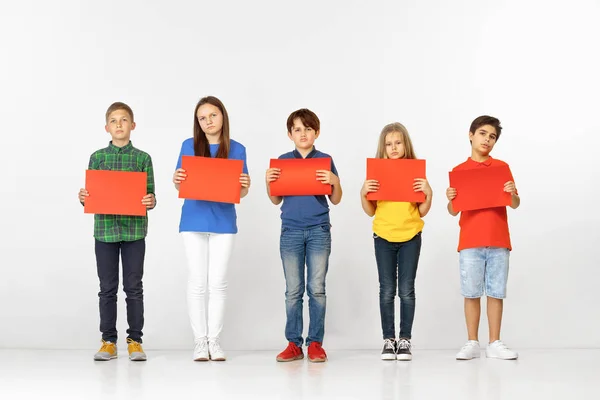Groep kinderen met rode banners geïsoleerd in wit — Stockfoto