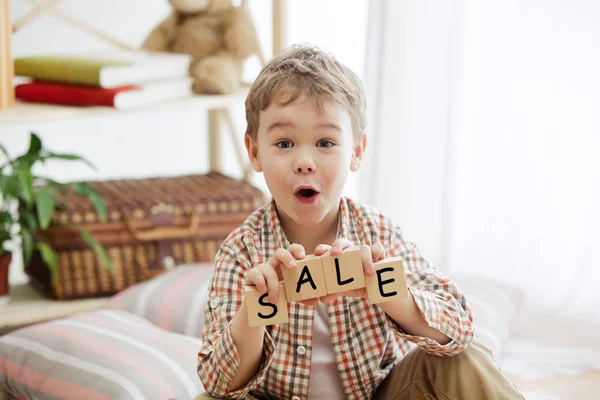 단어 판매 집에서 행복 하 게 웃는 어린 소년의 손에 나무 큐브 — 스톡 사진