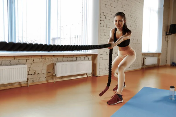 Woman with battle ropes exercise in the fitness gym. — Stock Photo, Image