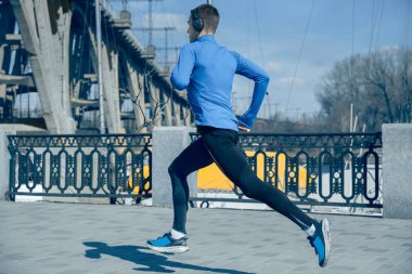 Sabah şehir arka plan üzerinde koşan adam.