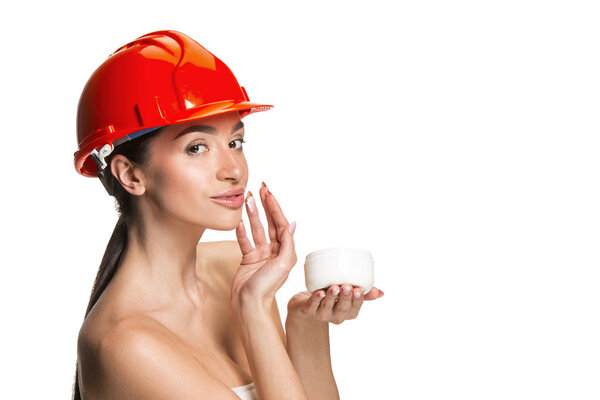 Portrait of confident female worker in orange helmet