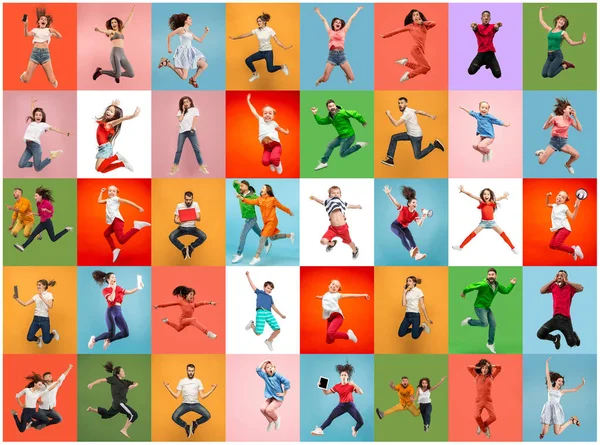 Liberdade em movimento. Muito jovens mulheres e homens pulando contra fundo colorido — Fotografia de Stock