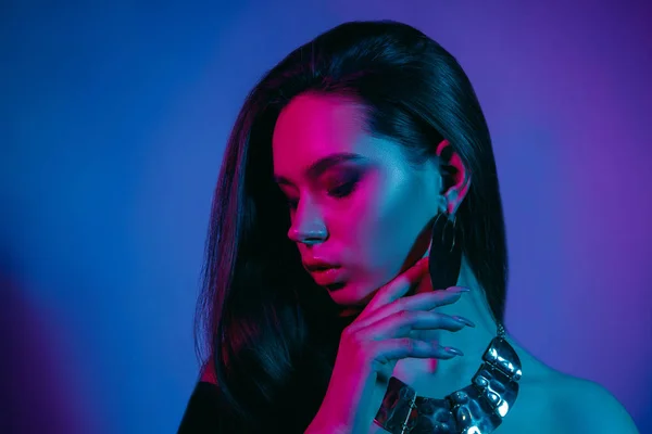 Modelo de alta moda em luzes de néon brilhantes coloridas posando no estúdio — Fotografia de Stock