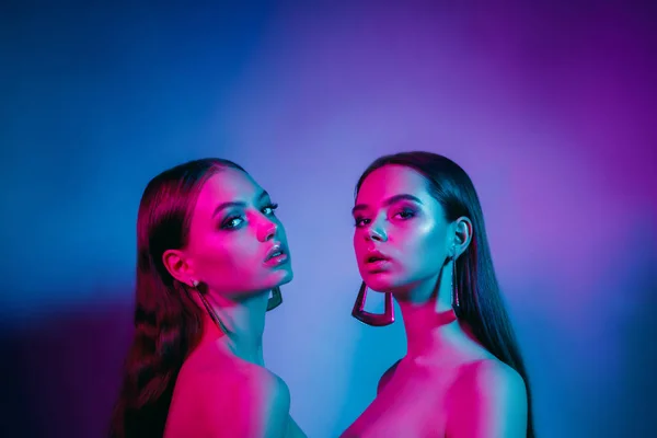 Modelos de alta moda em luzes de néon brilhantes coloridas posando no estúdio — Fotografia de Stock