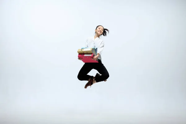 Mulher trabalhando no escritório e pulando isolado no fundo do estúdio — Fotografia de Stock