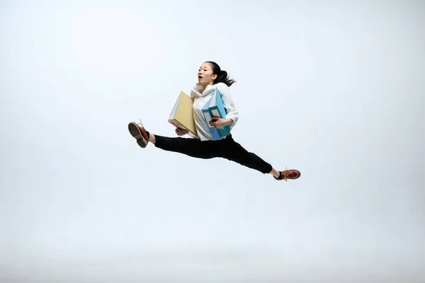 Жінка працює в офісі і стрибає ізольовано на студійному фоні — стокове фото