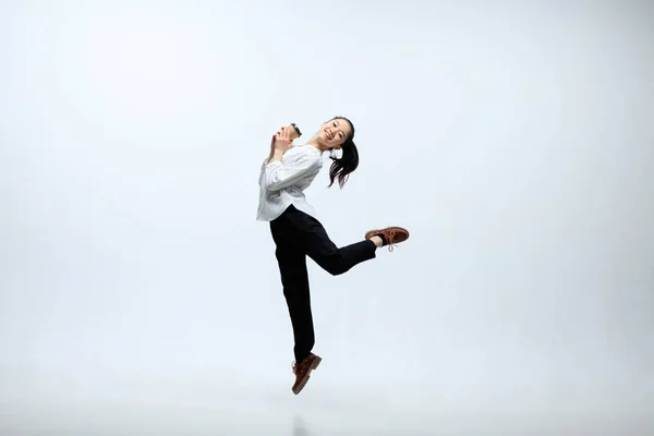 Жінка працює в офісі і стрибає ізольовано на студійному фоні — стокове фото