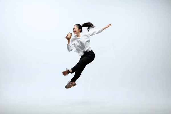 Mujer trabajando en la oficina y saltando aislado en el fondo del estudio —  Fotos de Stock