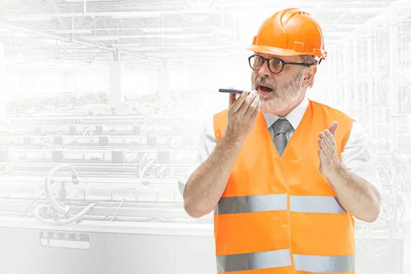 El constructor en casco naranja contra fondo industrial — Foto de Stock