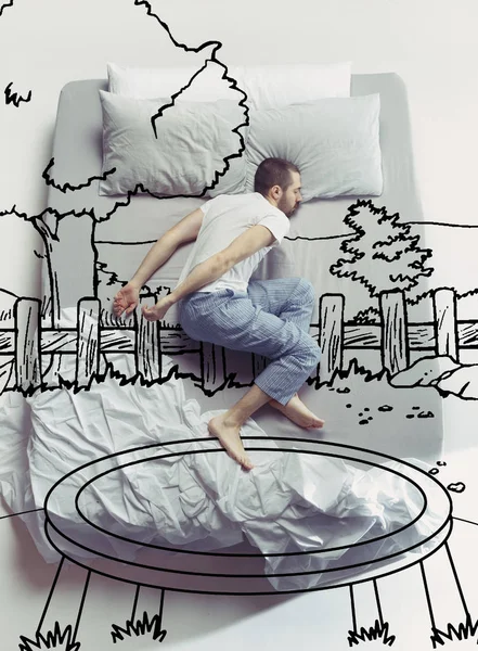 Ovanifrån foto av ung man sover i en stor vit säng och hans drömmar — Stockfoto