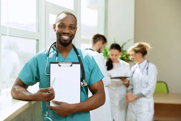 Красивий усміхнений африканський лікар на лікарняному фоні — стокове фото
