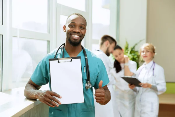 Красивий усміхнений африканський лікар на лікарняному фоні — стокове фото