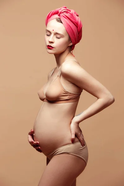 Kahverengi arka planda poz genç güzel hamile kadın — Stok fotoğraf
