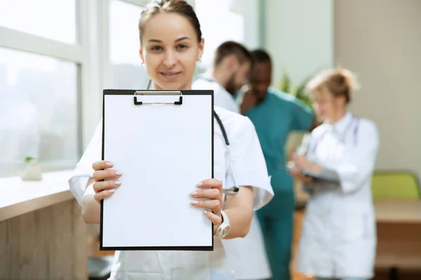 Hermoso médico sonriente sobre el fondo del hospital —  Fotos de Stock