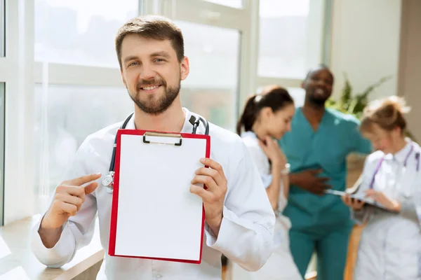 Hermoso médico sonriente sobre el fondo del hospital —  Fotos de Stock
