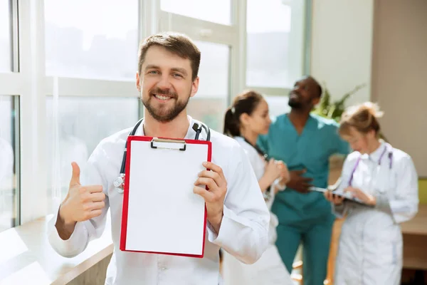 Hermoso médico sonriente sobre el fondo del hospital —  Fotos de Stock